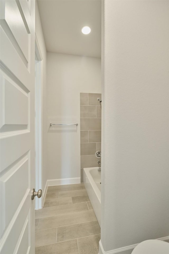 bathroom featuring wood finish floors, shower / tub combination, toilet, and baseboards