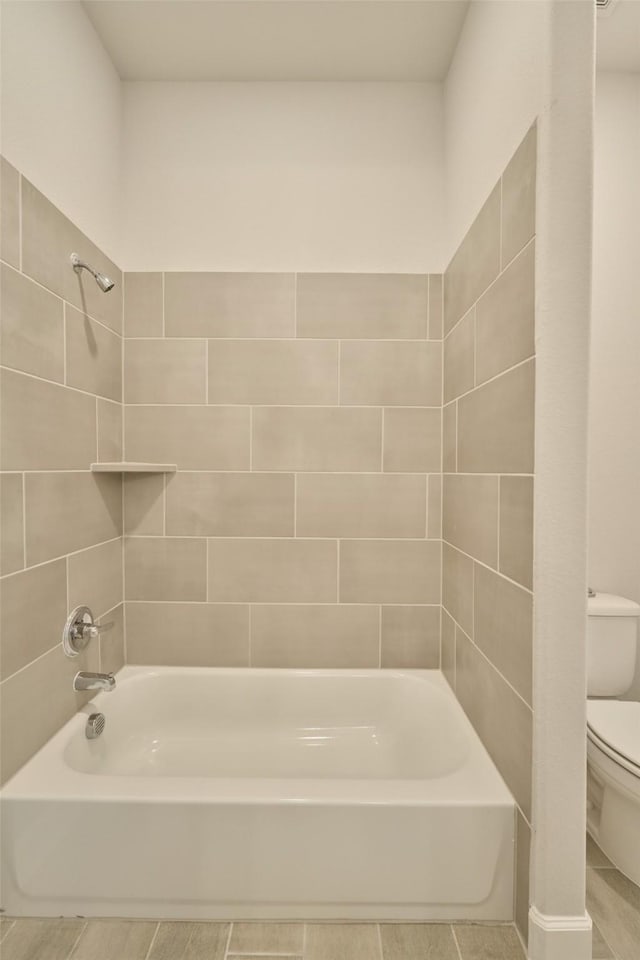 bathroom featuring bathing tub / shower combination and toilet