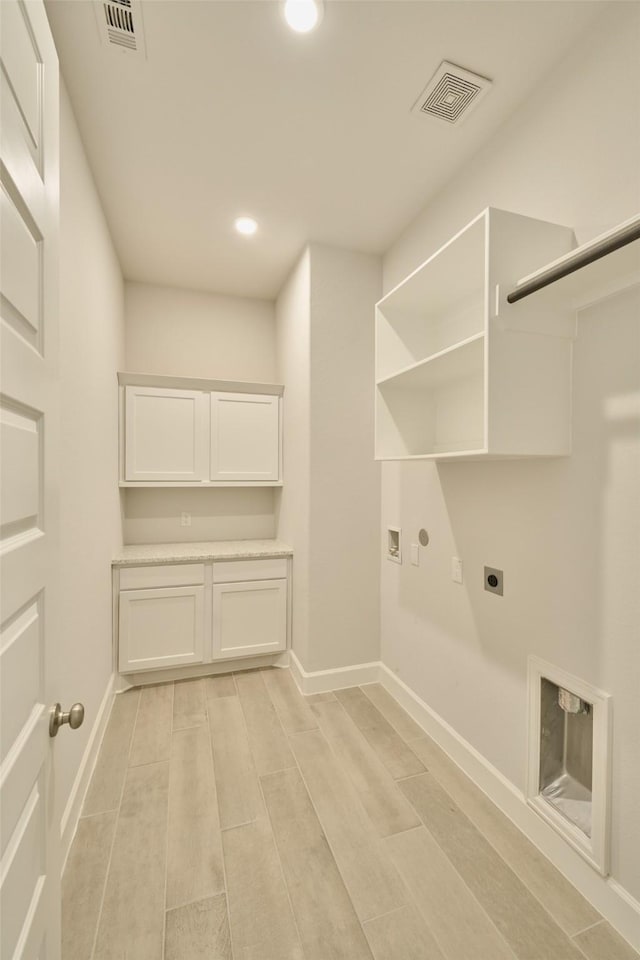 laundry area with baseboards, wood tiled floor, visible vents, and electric dryer hookup