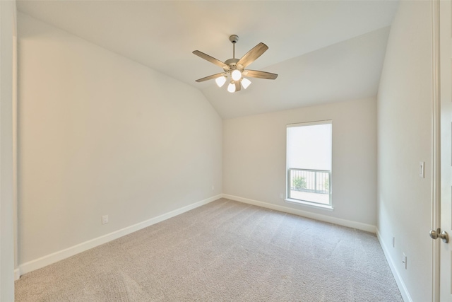 spare room with light carpet, ceiling fan, baseboards, and lofted ceiling