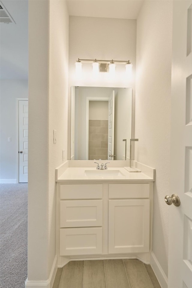 bathroom with visible vents, baseboards, and vanity