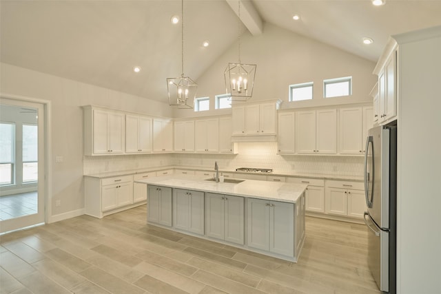 kitchen featuring appliances with stainless steel finishes, a center island with sink, and white cabinetry