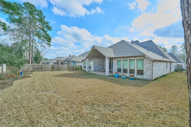 back of house with a patio area, brick siding, a yard, and a fenced backyard