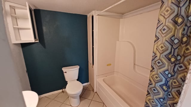 bathroom featuring tile patterned flooring, bathing tub / shower combination, and toilet