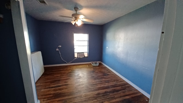 spare room with dark wood-type flooring, ceiling fan, and a textured ceiling