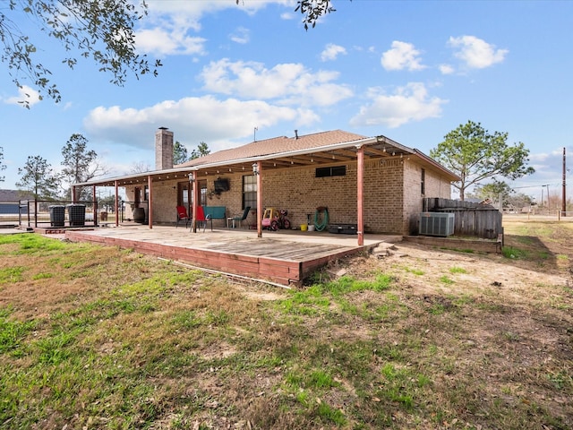 back of property with cooling unit, brick siding, fence, a chimney, and a patio area