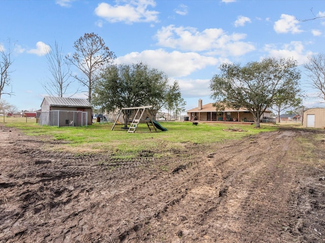 view of yard featuring a playground and an outdoor structure