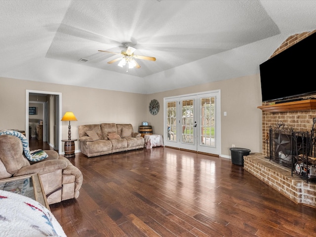 living room featuring ceiling fan, a textured ceiling, baseboards, and wood finished floors