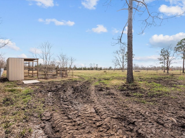 view of yard featuring a rural view and an outbuilding