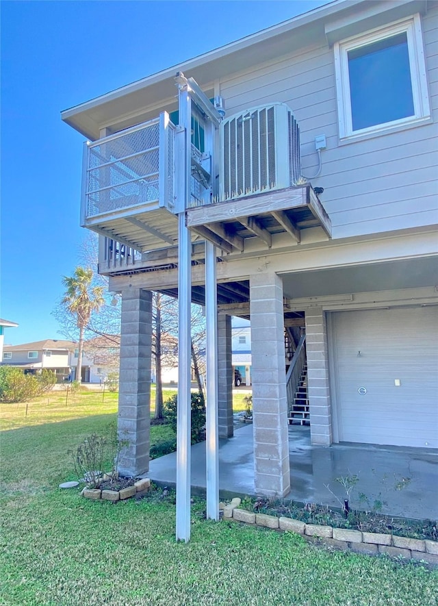 exterior space with a garage, a balcony, and a yard