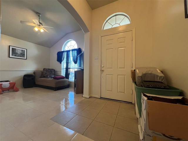 tiled foyer entrance with ceiling fan and lofted ceiling