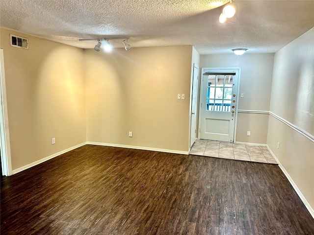 foyer featuring hardwood / wood-style floors, track lighting, and a textured ceiling