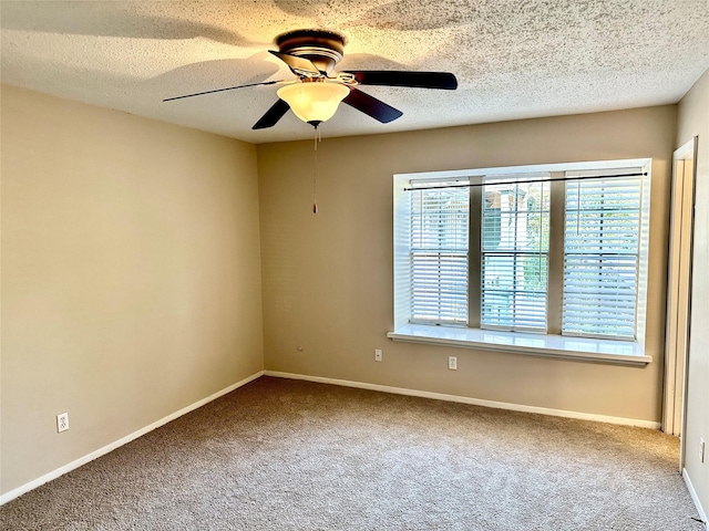 carpeted spare room featuring ceiling fan and a textured ceiling