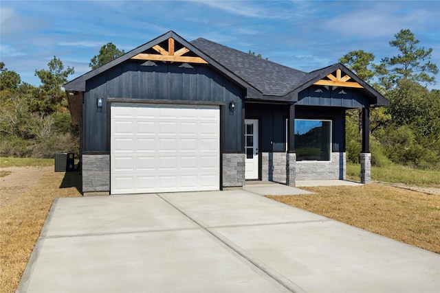 view of front facade featuring central AC unit, a garage, and a front lawn