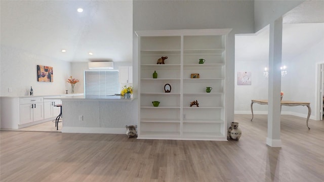 interior space featuring a wall mounted air conditioner and light wood-type flooring