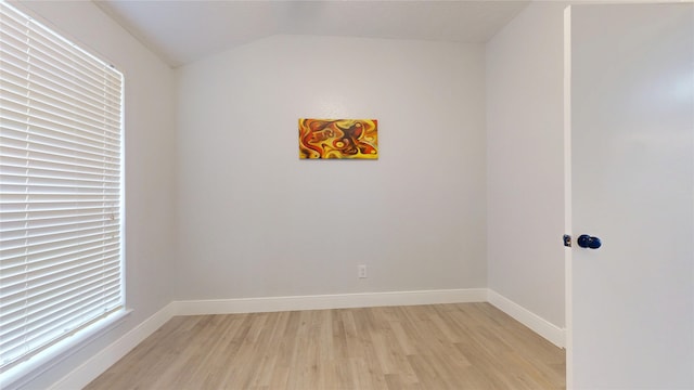 spare room featuring vaulted ceiling and light wood-type flooring