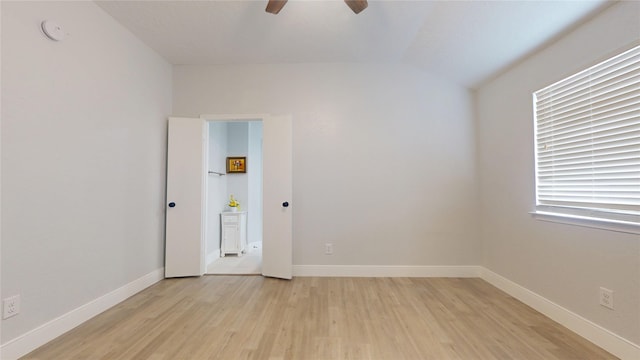 spare room featuring ceiling fan, lofted ceiling, and light hardwood / wood-style floors