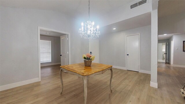 dining space with high vaulted ceiling and light hardwood / wood-style floors