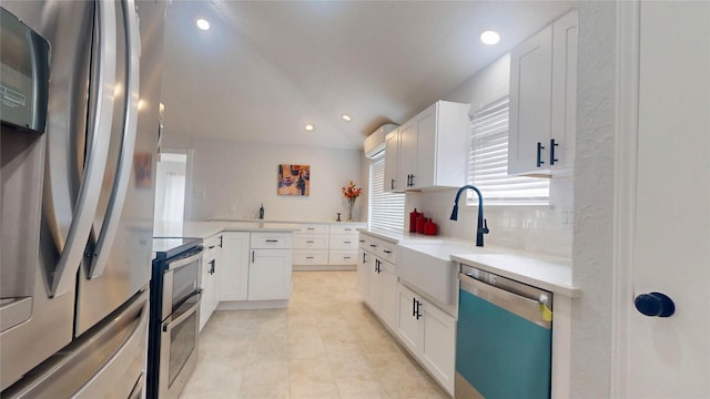 kitchen featuring white cabinetry, lofted ceiling, sink, backsplash, and stainless steel appliances