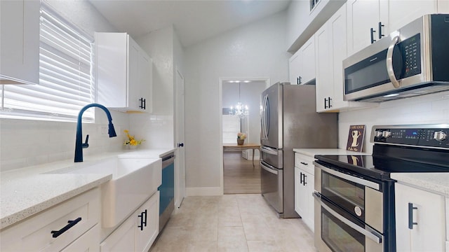 kitchen with white cabinetry, appliances with stainless steel finishes, and light stone countertops