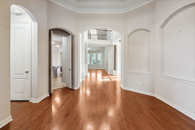 hall with wood-type flooring and ornamental molding