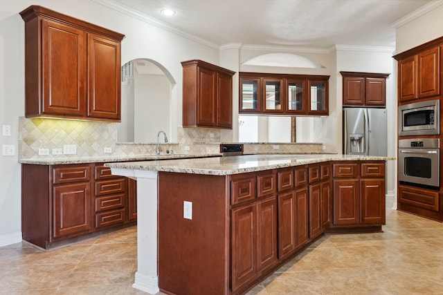 kitchen with stainless steel appliances, a center island, light stone counters, and decorative backsplash