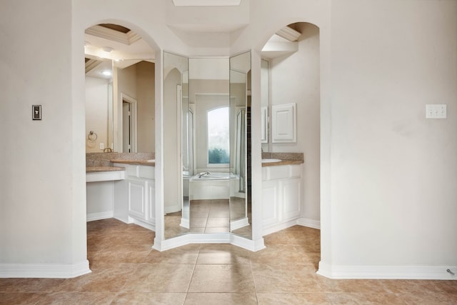 bathroom with tile patterned flooring, vanity, and a bath