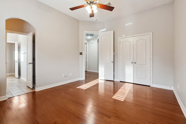 unfurnished bedroom featuring ceiling fan, light wood-type flooring, and a closet