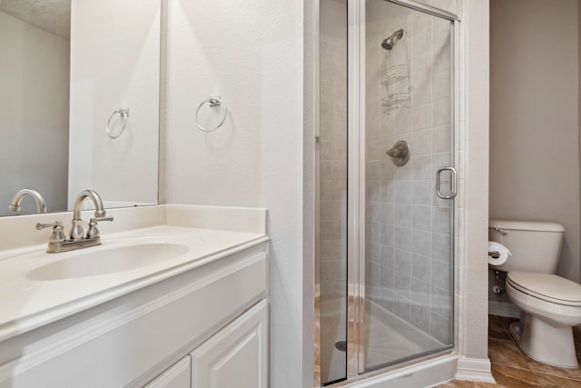 bathroom featuring vanity, toilet, and a shower with door