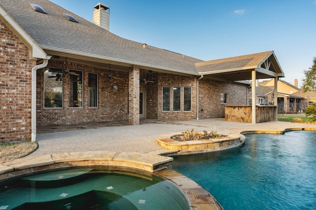 view of swimming pool with a patio, an outdoor bar, ceiling fan, and an in ground hot tub