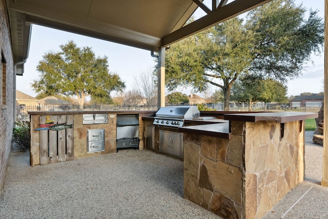 view of patio with an outdoor kitchen and a grill