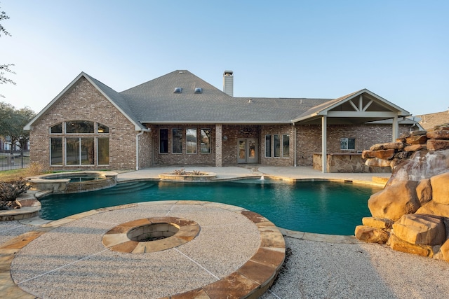 view of swimming pool featuring a fire pit, a patio, and an in ground hot tub