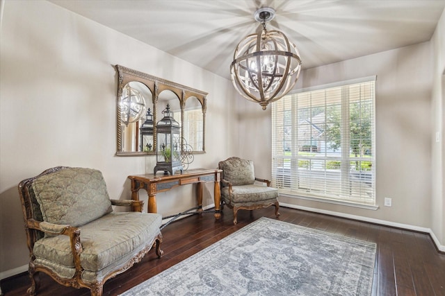 sitting room featuring dark wood-type flooring and a notable chandelier