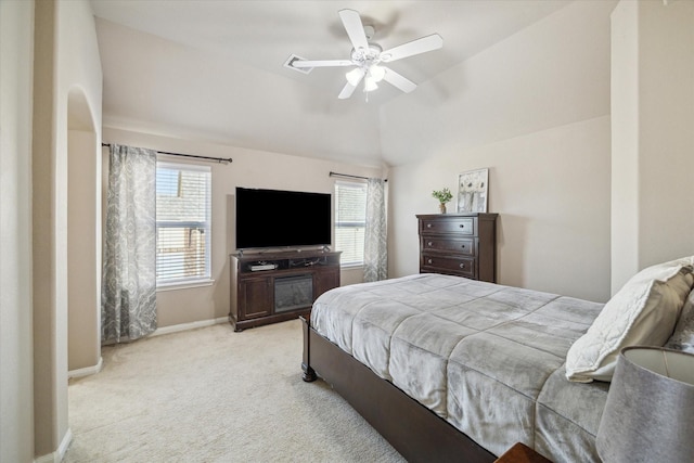 carpeted bedroom featuring ceiling fan, multiple windows, and lofted ceiling