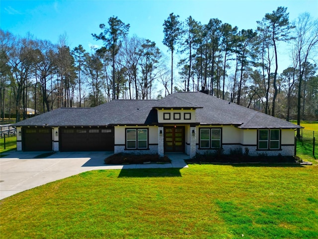 prairie-style home with a garage, concrete driveway, a front yard, and stucco siding