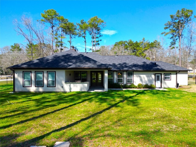 rear view of property featuring a yard, french doors, and roof with shingles