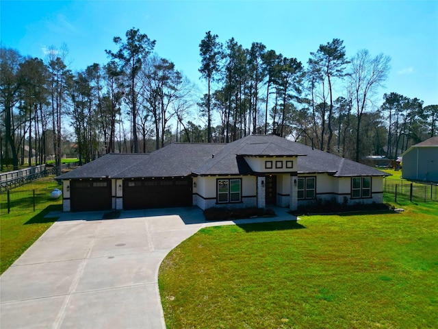 prairie-style house with a front yard, fence, driveway, and an attached garage