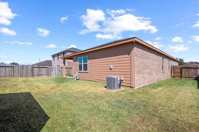 back of property with cooling unit and a yard