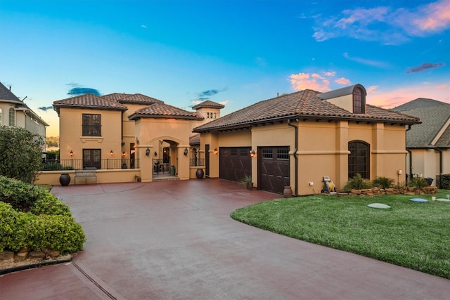 mediterranean / spanish-style house featuring a garage and a lawn