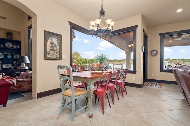 tiled dining room with plenty of natural light, a chandelier, and built in shelves