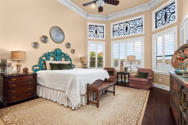 bedroom featuring dark hardwood / wood-style flooring, crown molding, multiple windows, and a towering ceiling