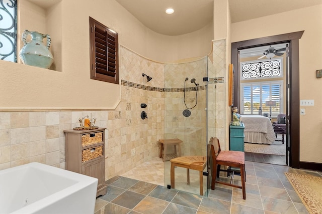 bathroom featuring tile walls, independent shower and bath, and ceiling fan