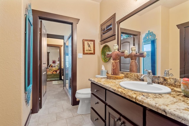 bathroom with vanity, tile patterned floors, and toilet