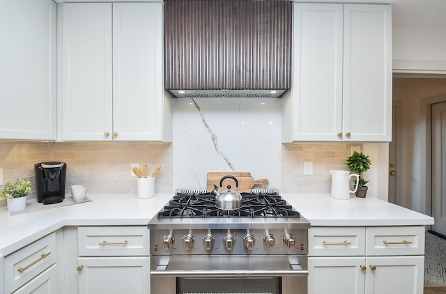 kitchen featuring exhaust hood, white cabinets, high end range, and decorative backsplash