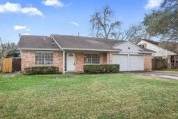 ranch-style home featuring a garage and a front lawn