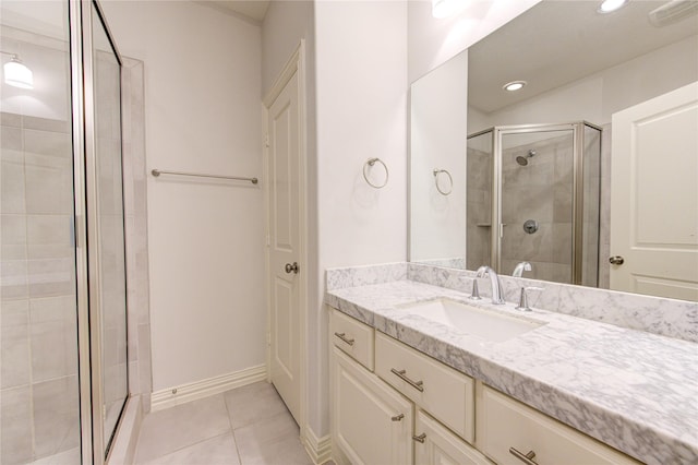 bathroom featuring tile patterned flooring, vanity, and a shower with shower door