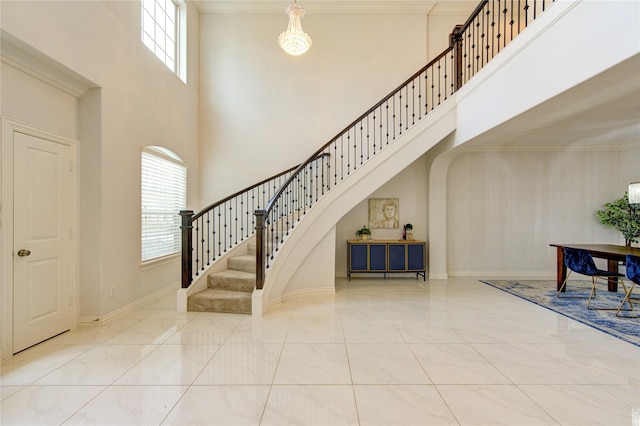 foyer featuring a towering ceiling and ornamental molding