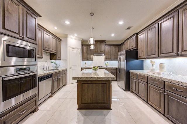 kitchen featuring dark brown cabinetry, sink, a center island, hanging light fixtures, and appliances with stainless steel finishes