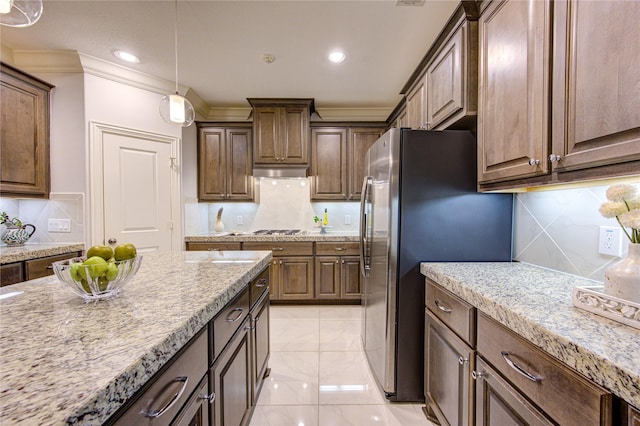 kitchen with crown molding, light stone counters, decorative light fixtures, stainless steel appliances, and backsplash