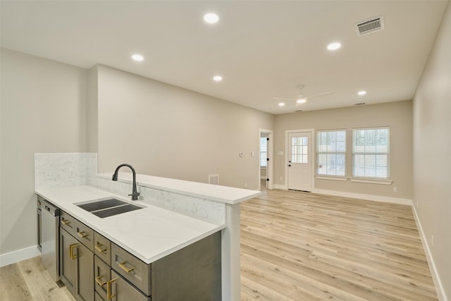 kitchen featuring sink, light wood-type flooring, kitchen peninsula, dishwasher, and ceiling fan